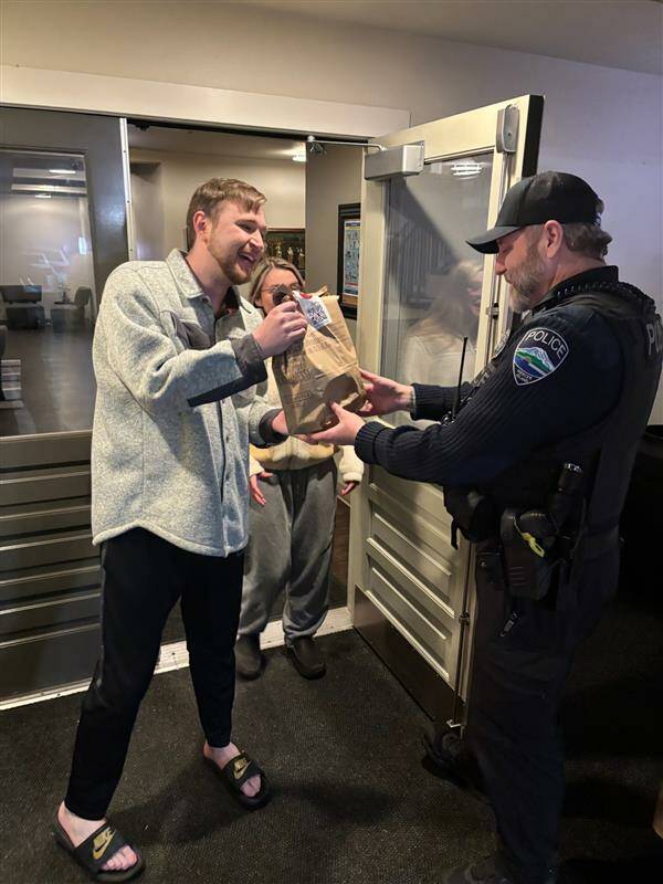 Mercer Island Police Department (MIPD) officer Todd Roggenkamp makes a DoorDash delivery on Jan. 2. During a traffic stop, officers arrested a delivery driver on an outstanding warrant, leaving a dinner order without a driver. Not giving it a second thought, our officers completed the delivery to some very happy residents, MIPD said. Photo courtesy of the Mercer Island Police Department