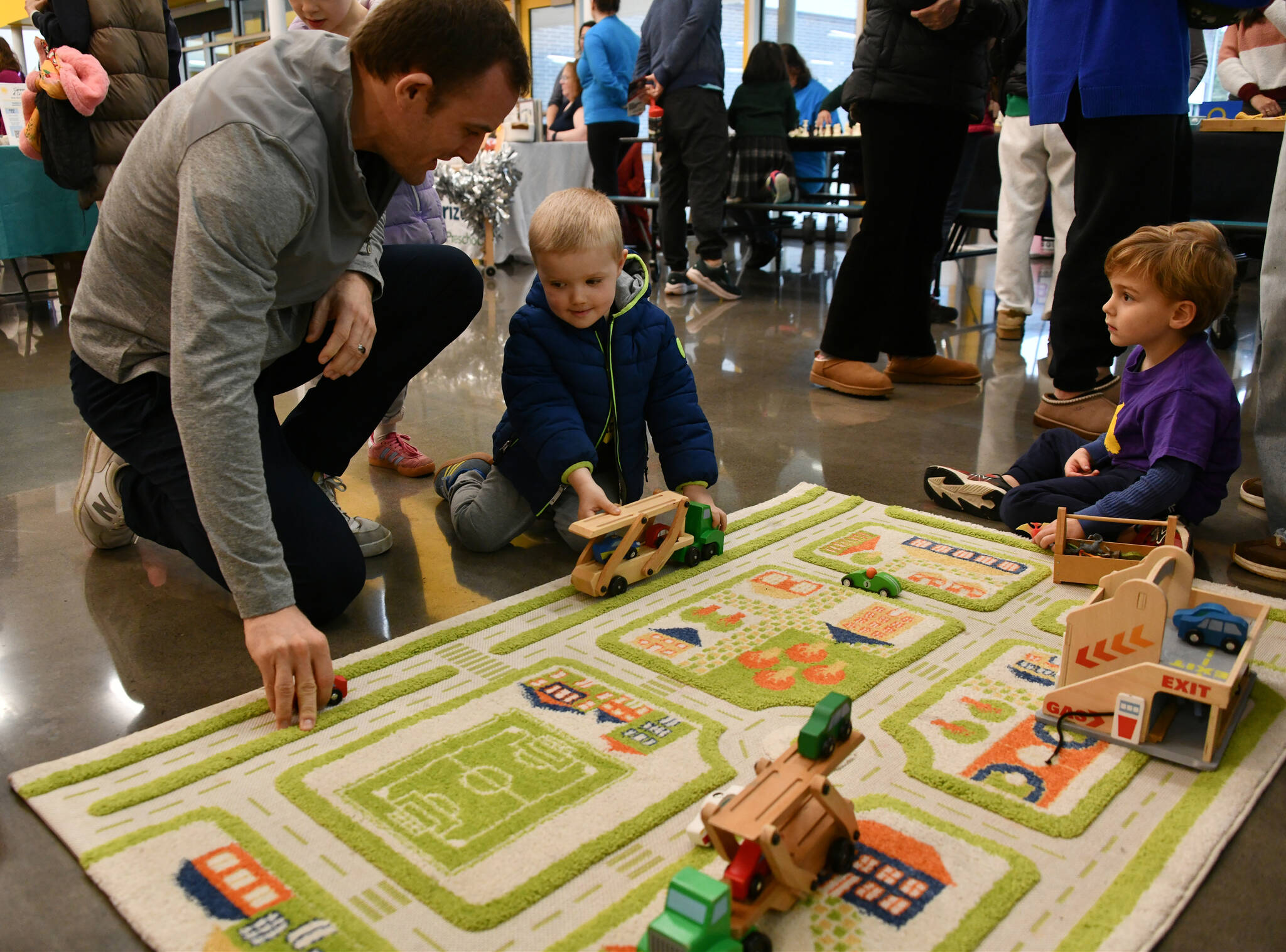 Matt Beeninga, his son Ryan, 4, and Blake Smith, 3, enjoy their time playing with trucks at the Pixie Hill Preschool booth at the Mercer Island Preschool Association (MIPA) Preschools and Activities Fair on Jan. 31 at Northwood Elementary School commons. The fair featured a variety of preschool programs representing diverse languages, cultures and educational philosophies, including French, Spanish and Chinese programs. Families met school leaders and teachers, asked questions and explored options that best fit their childs unique needs and interests. In addition, extracurricular providers offered activities ranging from dance and ballet to martial arts, lacrosse, soccer and basketball, helping children build confidence, creativity, teamwork and physical skills. Andy Nystrom/ staff photo