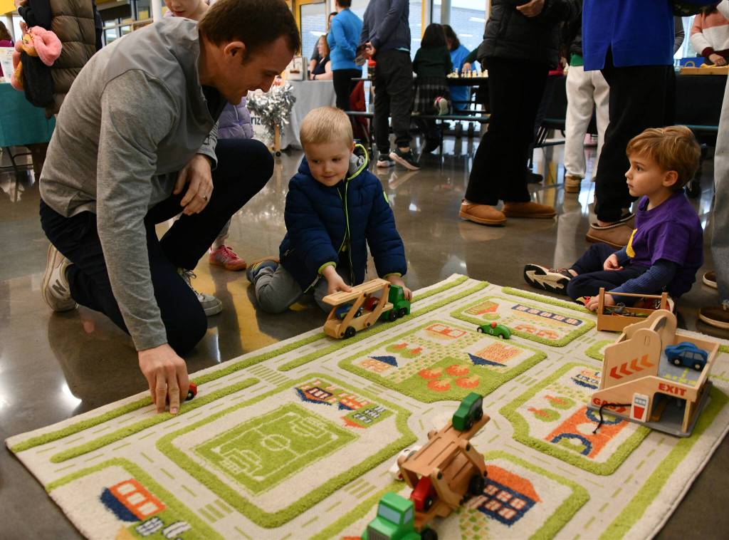 Matt Beeninga, his son Ryan, 4, and Blake Smith, 3, enjoy their time playing with trucks at the Pixie Hill Preschool booth at the Mercer Island Preschool Association (MIPA) Preschools and Activities Fair on Jan. 31 at Northwood Elementary School commons. The fair featured a variety of preschool programs representing diverse languages, cultures and educational philosophies, including French, Spanish and Chinese programs. Families met school leaders and teachers, asked questions and explored options that best fit their childs unique needs and interests. In addition, extracurricular providers offered activities ranging from dance and ballet to martial arts, lacrosse, soccer and basketball, helping children build confidence, creativity, teamwork and physical skills. Andy Nystrom/ staff photo
