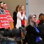 Washington Education Association (WEA) members hold signs that read, raise revenue, fund our schools at the town hall.