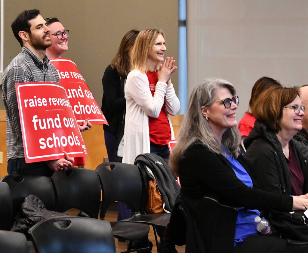 Washington Education Association (WEA) members hold signs that read, raise revenue, fund our schools at the town hall.