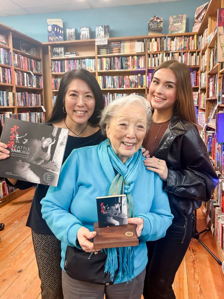 Three generations of Mercer Island residents: Author Kelly Goto (left), daughter Kirin Lancaster (right) and mother Dee Goto (front, holding her daughters 2026 Pacific Northwest Booksellers Association award). Courtesy photo
