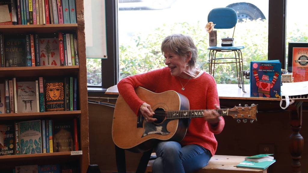 Stewart plays the guitar between books at storytime. The guitar gives Stewart the opportunity to sing songs like The Wheels on the Bus and Down by the Bay. Photo by Addie Stoterau
