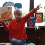 Nancy Stewart reads I Love Animals by Flora McDonnell to start Sing-Along Storytime on April 18, 2026, at Island Books. Stewart gets very involved in her storytelling, using facial expressions and hand gestures to dramatize the stories. Photo by Addie Stoterau