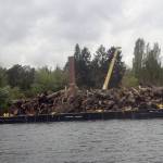 A barge filled with about 200 tons of debris from Lake Washington is pulled past the boiler building off Luther Burbank Park. Photo courtesy of the city of Mercer Island