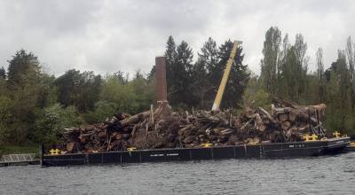 A barge filled with about 200 tons of debris from Lake Washington is pulled past the boiler building off Luther Burbank Park. Photo courtesy of the city of Mercer Island