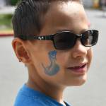Michael Larson, 7, displays his king cobra temporary tattoo that he received at the Community Day of Inclusion. Andy Nystrom/ staff photo