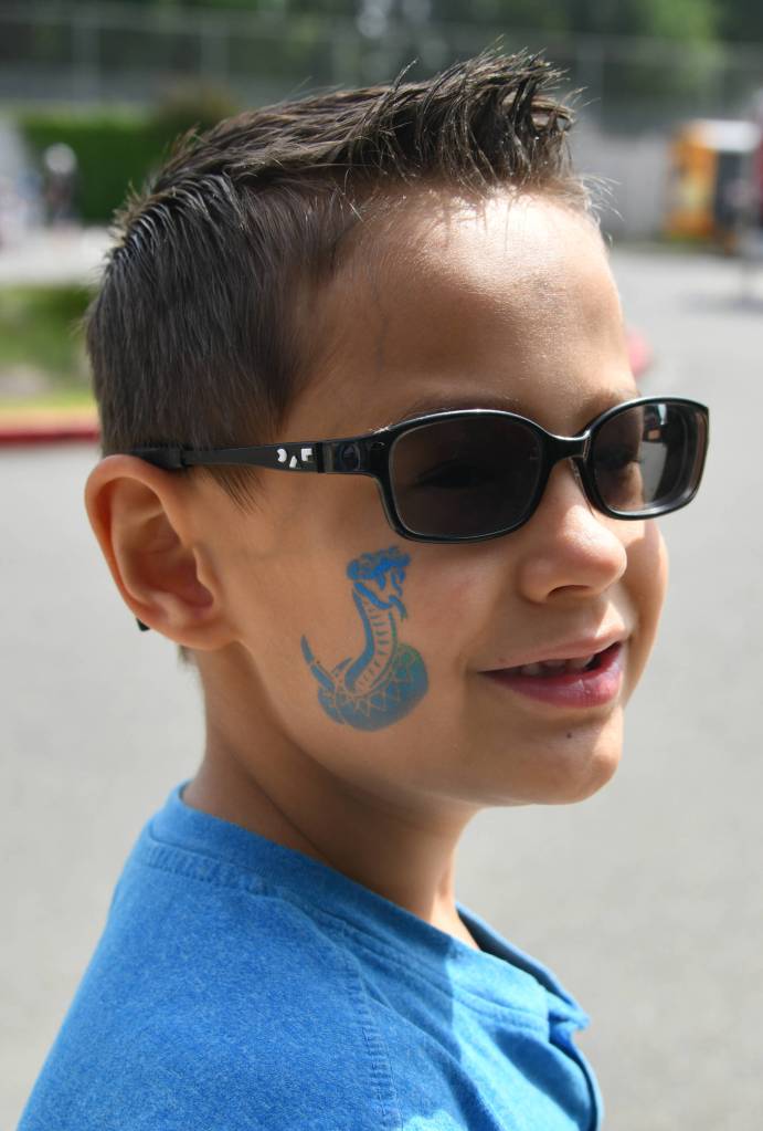 Michael Larson, 7, displays his king cobra temporary tattoo that he received at the Community Day of Inclusion. Andy Nystrom/ staff photo